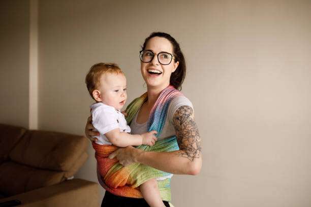 a young mother and her baby use baby carrier