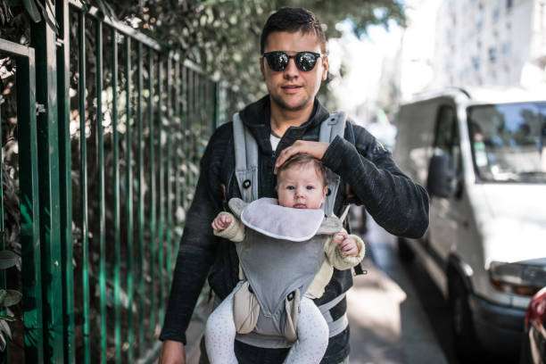 Man walking with his baby in the city.baby carrier