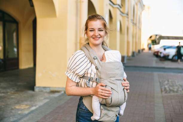Active young mother with baby carrier