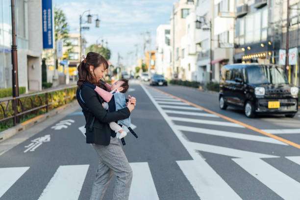 A mother takes her baby hiking in a baby carrier.