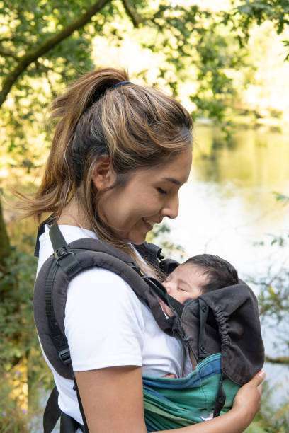The baby fell asleep in the baby carrier.