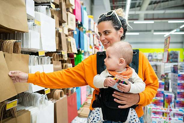 Mother is carrying her daughter in baby carrier during a walk.