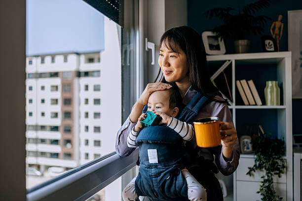 A young mother with her daughter in sling Baby Carrier