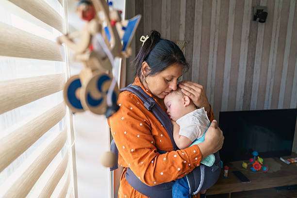 A young mother with her daughter in sling Baby Carrier