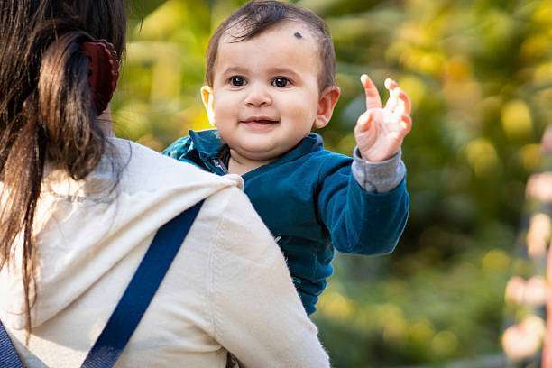 A young mother with her daughter in sling Baby Carrier
