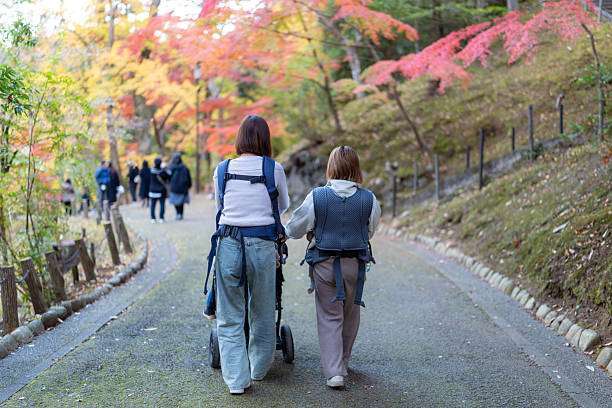 Happy woman looking to distance while holding and carrying it in a baby carrier in a park